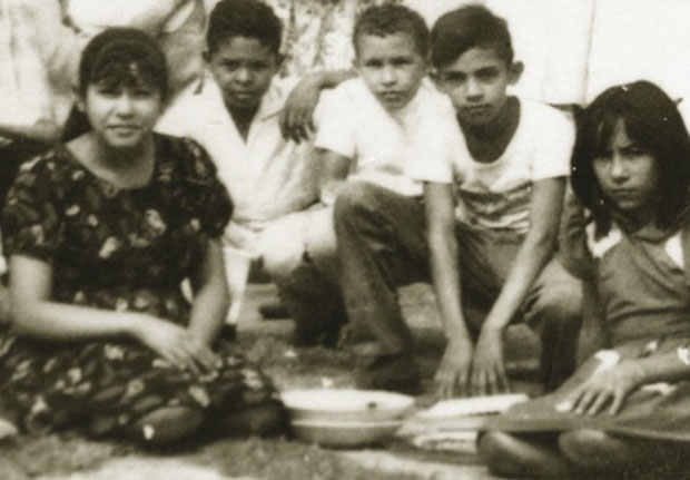 نفر وسط همراه با هم‌مدرسه‌ای‌هایش در زادگاهش شهر پینسابا